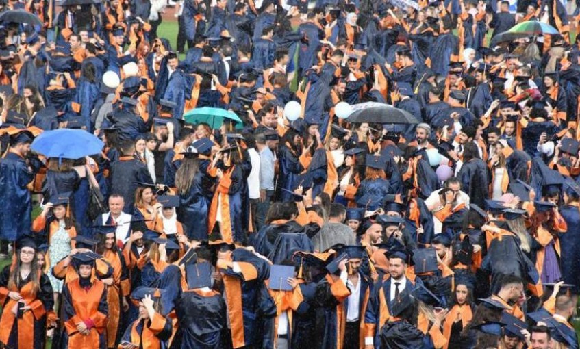 Mezun olan üniversite öğrencileri yağmur altında kep attı